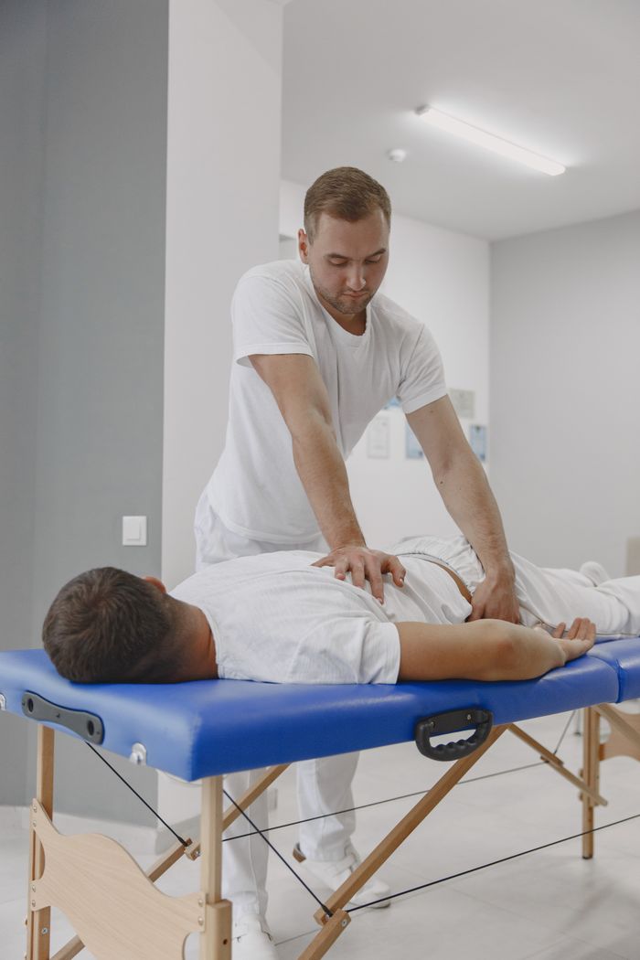 Chiropractor conducting a therapy session for back pain relief in a massage room.